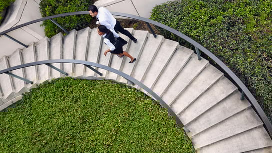 High angle view of business people ascending spiral stairway