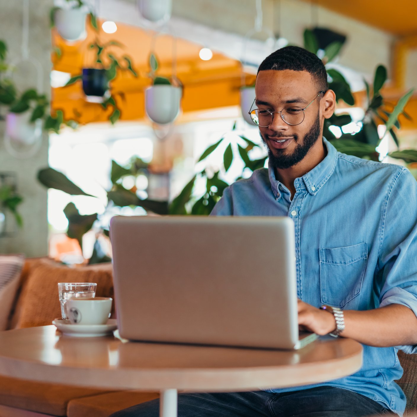  Young man sitting in city cafe and using laptop computer