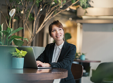 Happy Asian female using laptop working outdoors, web conference, remote work concept
