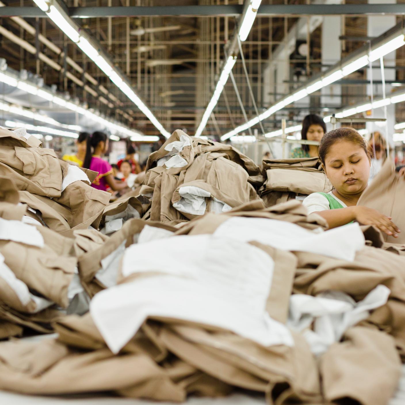 Workers folding clothing in garment factory