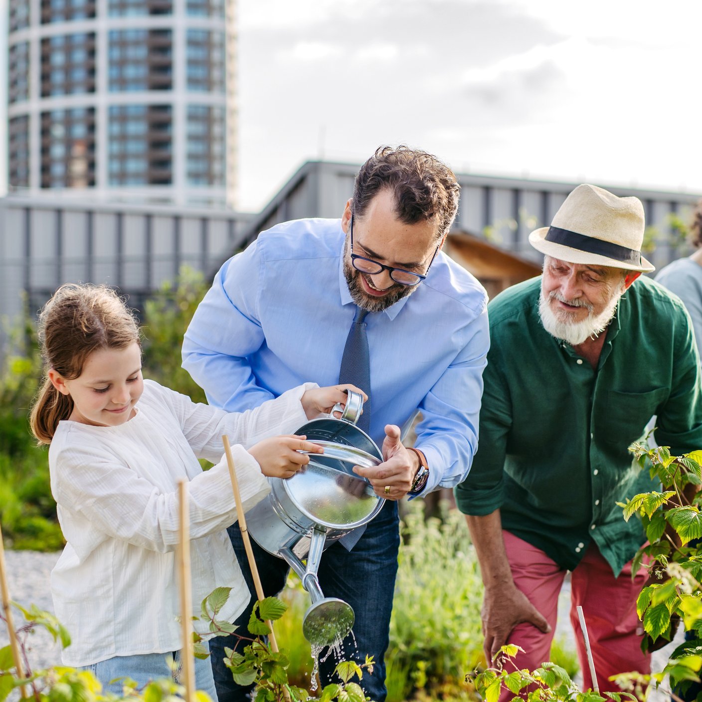 Neighbours taking care together of their community garden in a city.