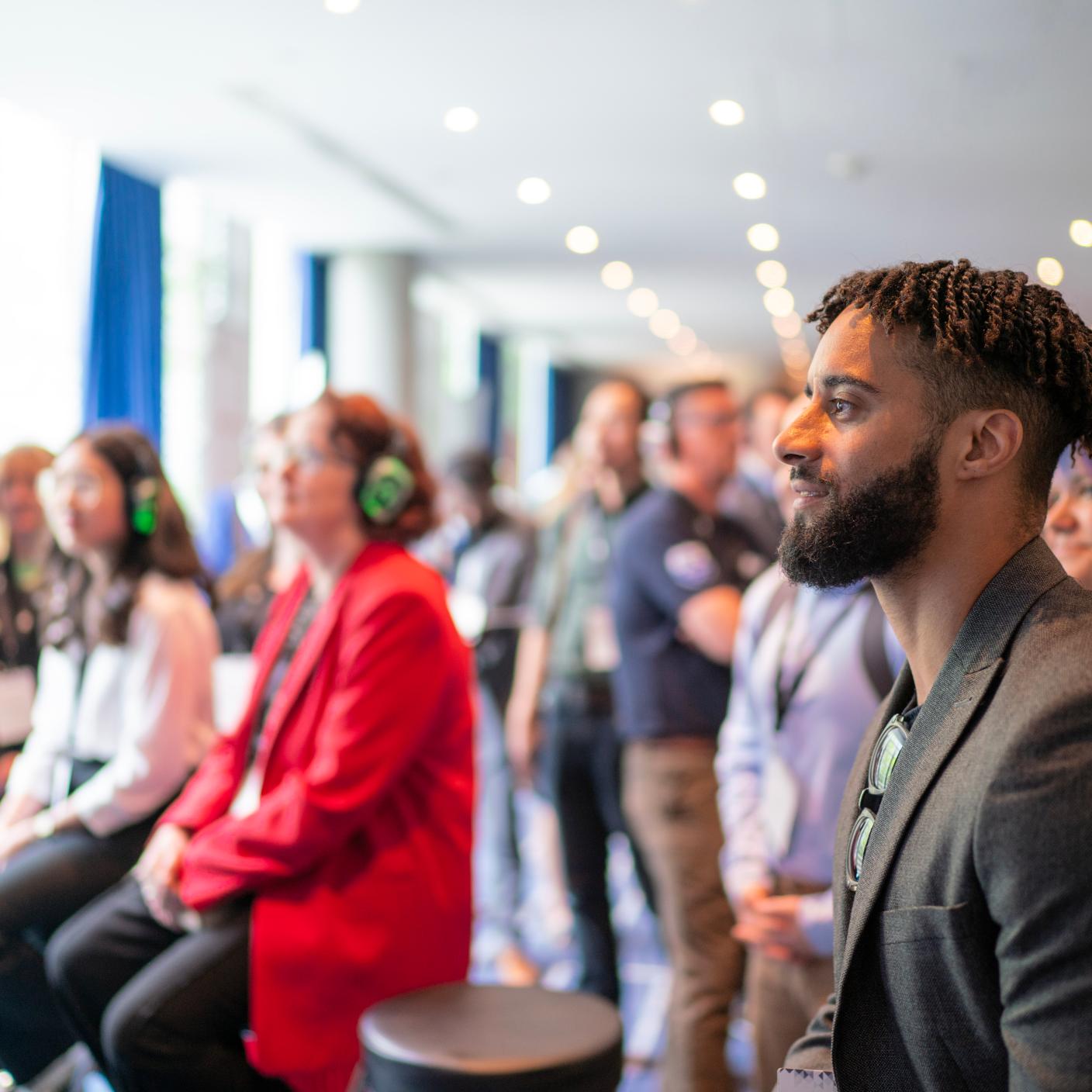 Crowd listening to speaker with wireless headphones