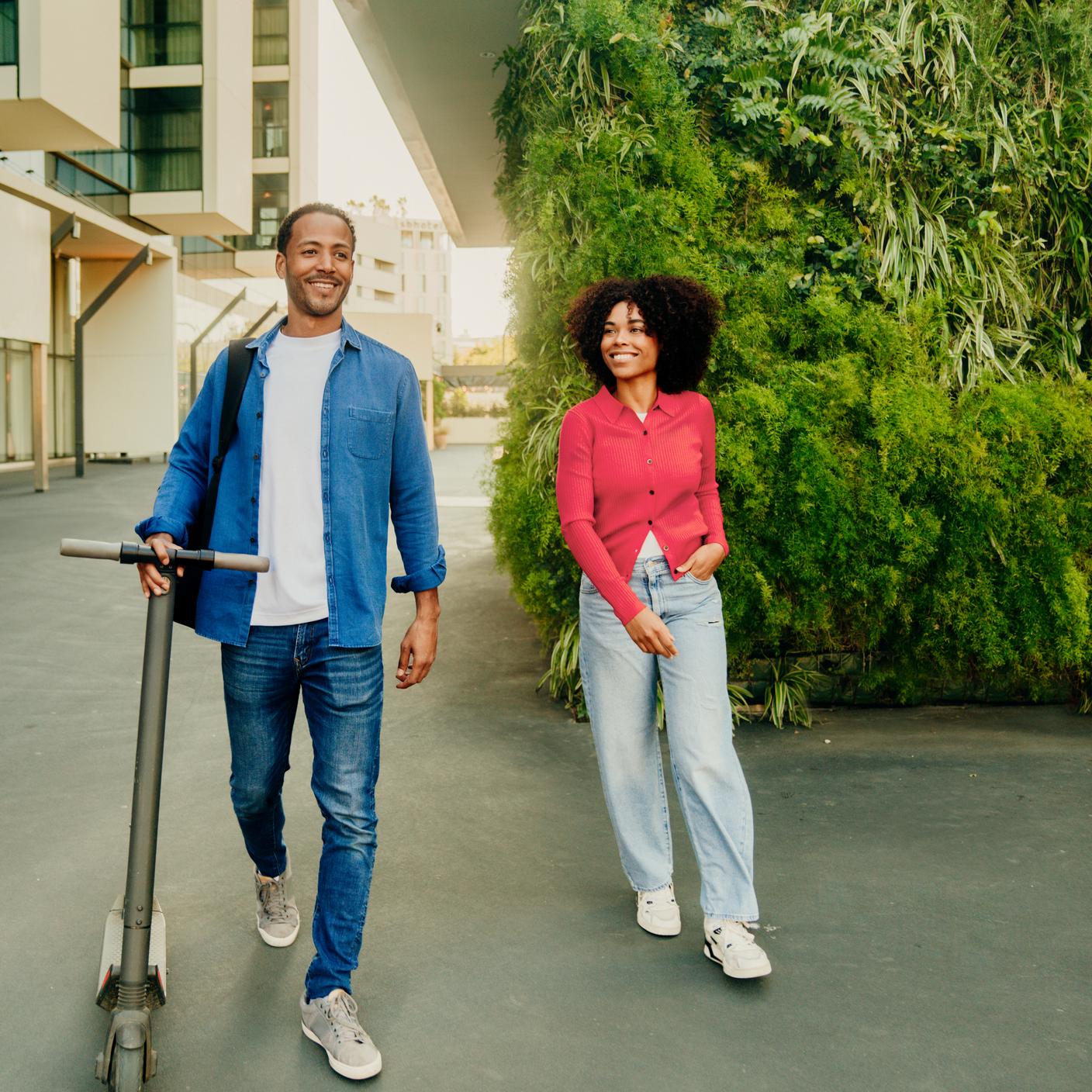 คู่รักยิ้มขณะเดินอยู่ในพื้นที่เมืองสีเขียว