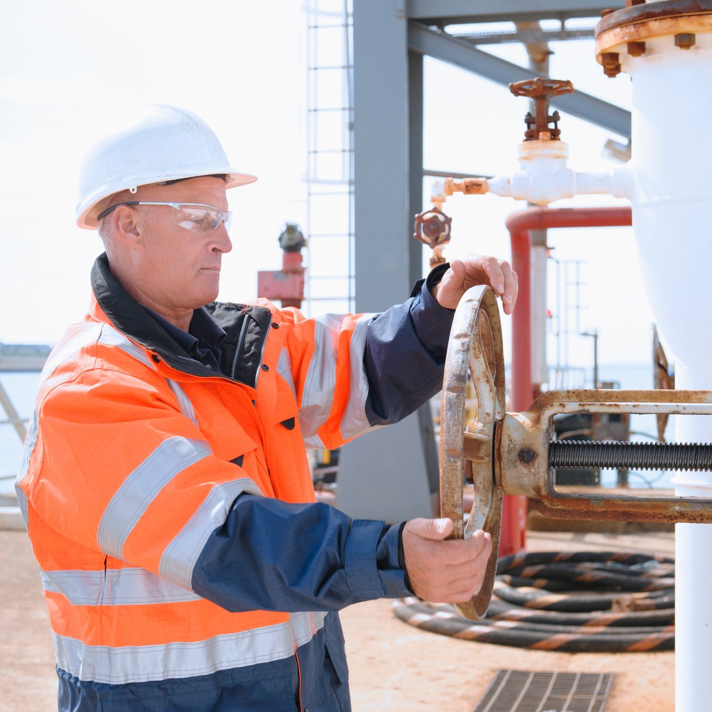 Man turning wheel on cargo ship 