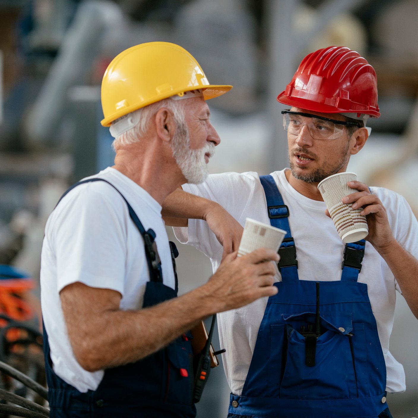 Manual workers having a coffee break in industrial building