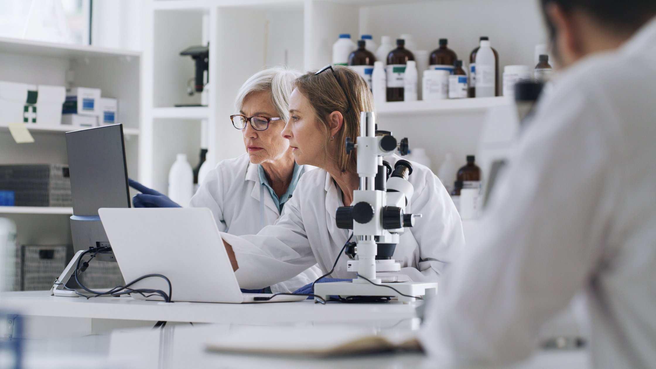 Scienziate in laboratorio con laptop e apparecchiature