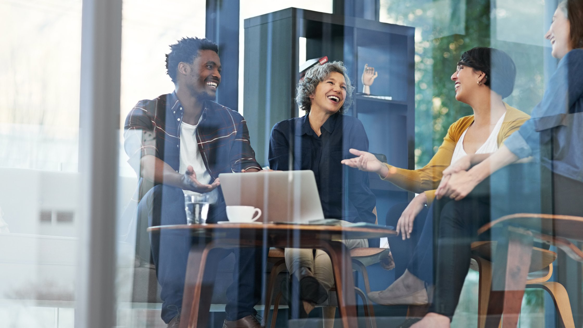 Shot of a team of creative businesspeople brainstorming around a laptop in the office